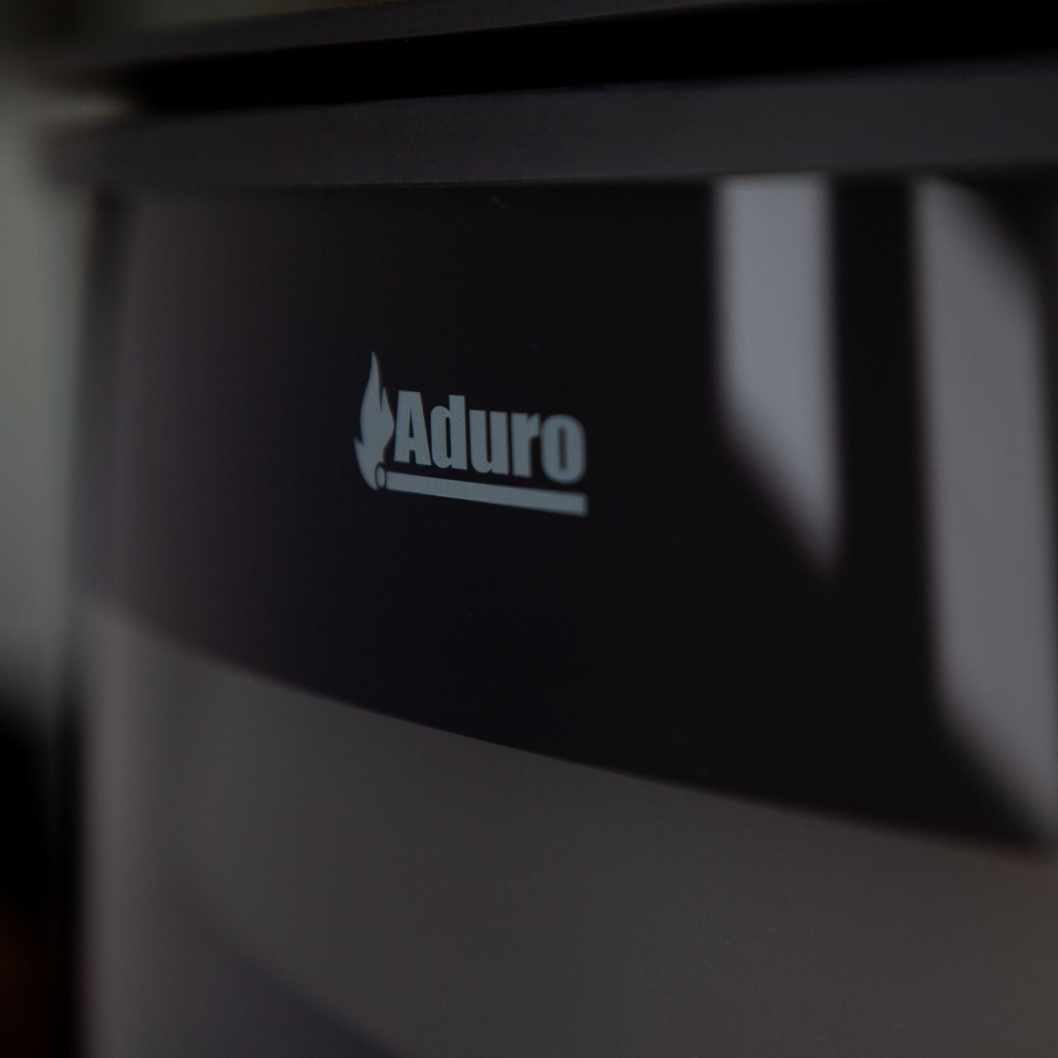 Detaljebillede af Aduro logo på brændeovn
