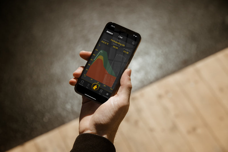 Hånd der holder smartphone, som er inde på Aduro Cloud app